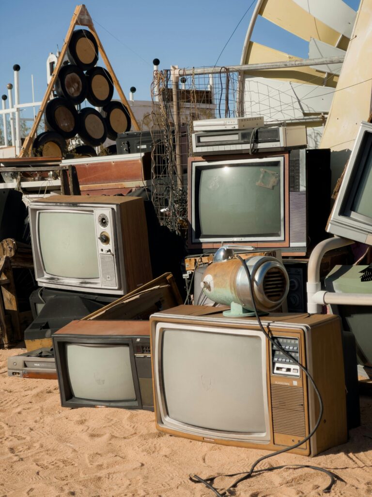 Photo of old, outdated televisions stacked and ready to be hauled away. The TVs are gathered in a cluttered pile, showcasing their condition before being removed by a junk hauling service. The image highlights the company's capability to efficiently manage and dispose of electronic waste.