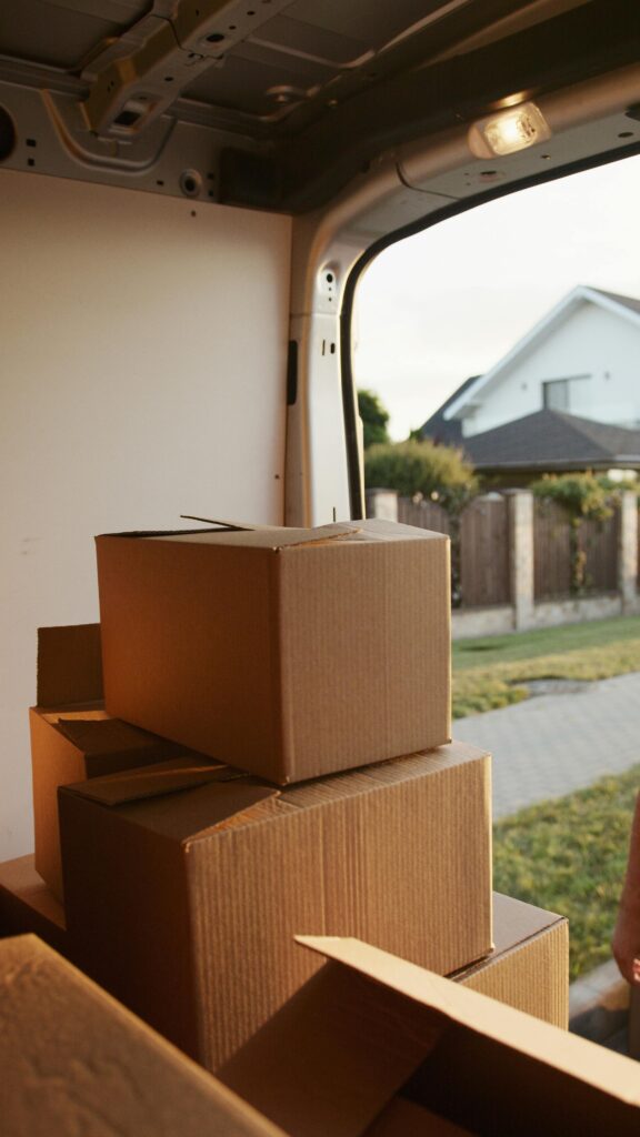 Photo of neatly stacked boxes in the back of a moving truck, organized for transport. The boxes are clearly labeled and secured, showcasing the moving company's commitment to efficient packing and careful handling of belongings during a move.