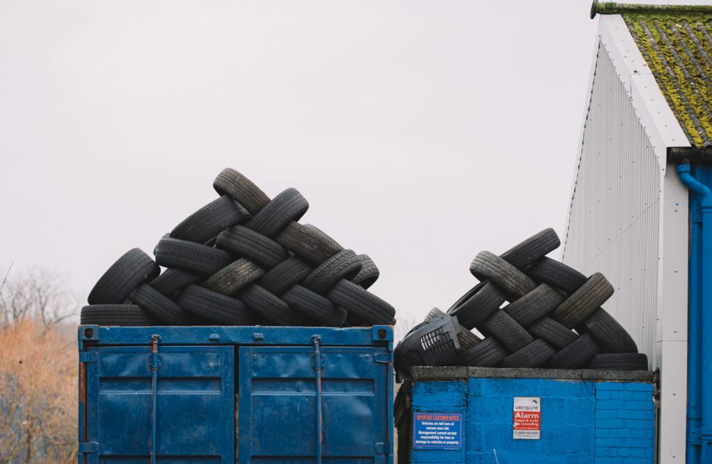 Photo of dumpsters filled with old tires, stacked and ready for disposal. The image shows the tires piled high, emphasizing the scale of waste being managed. It highlights the junk hauling service’s capability to handle and properly dispose of large quantities of tire waste.