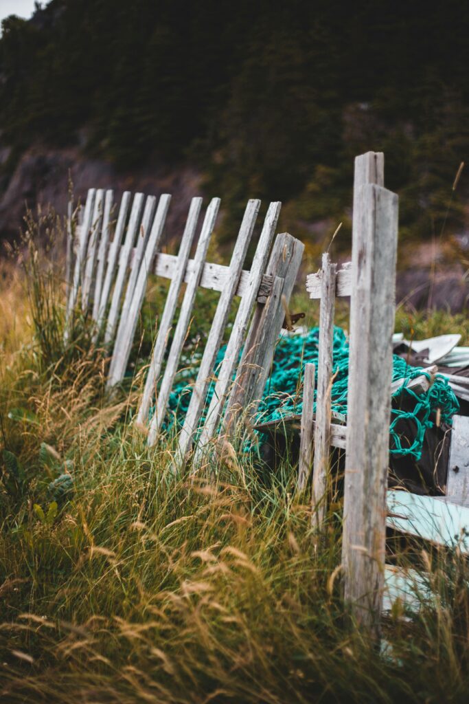 Photo of a scrap wood fence, showing weathered and disassembled wooden planks ready to be hauled away. The fence is piled in disarray, highlighting its condition before being removed by a junk hauling service. The image emphasizes the company's role in efficiently clearing and disposing of unwanted materials.