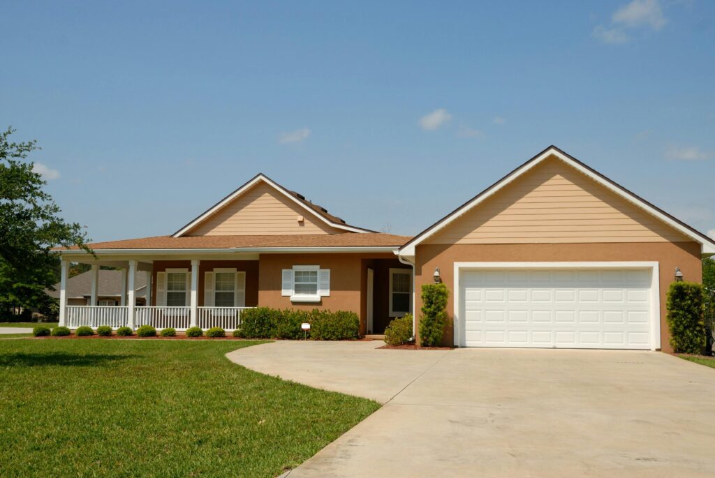 Photo of a house in a suburban neighborhood in Gresham. The home features a well-manicured lawn, a charming front porch, and neatly trimmed landscaping. The setting captures the peaceful, family-friendly atmosphere of the suburban area, showcasing a welcoming residential environment.