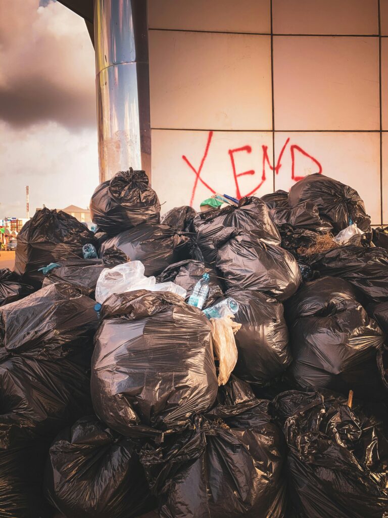 Photo of trash bags piled up in a designated area, ready for collection. The bags are stacked neatly, showcasing a large volume of waste. The image emphasizes the junk hauling service's ability to manage and remove significant amounts of refuse efficiently.